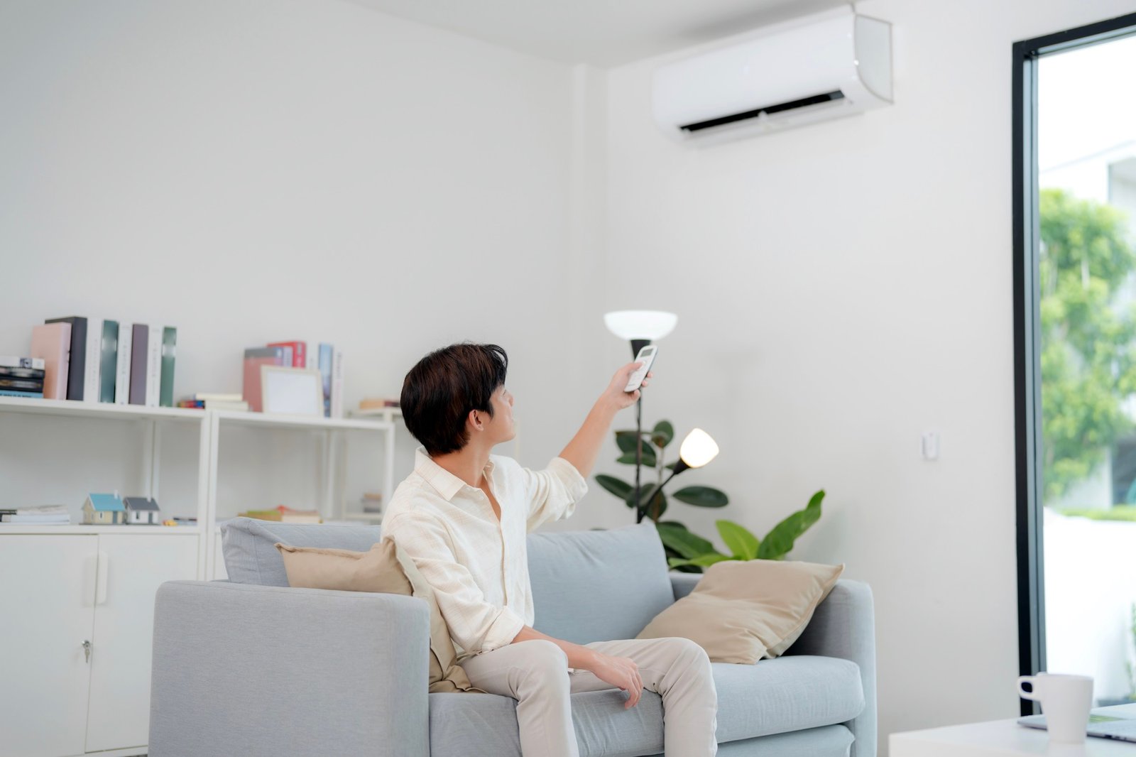 Man Operating Air Conditioning With Remote Control EFFJ6XX